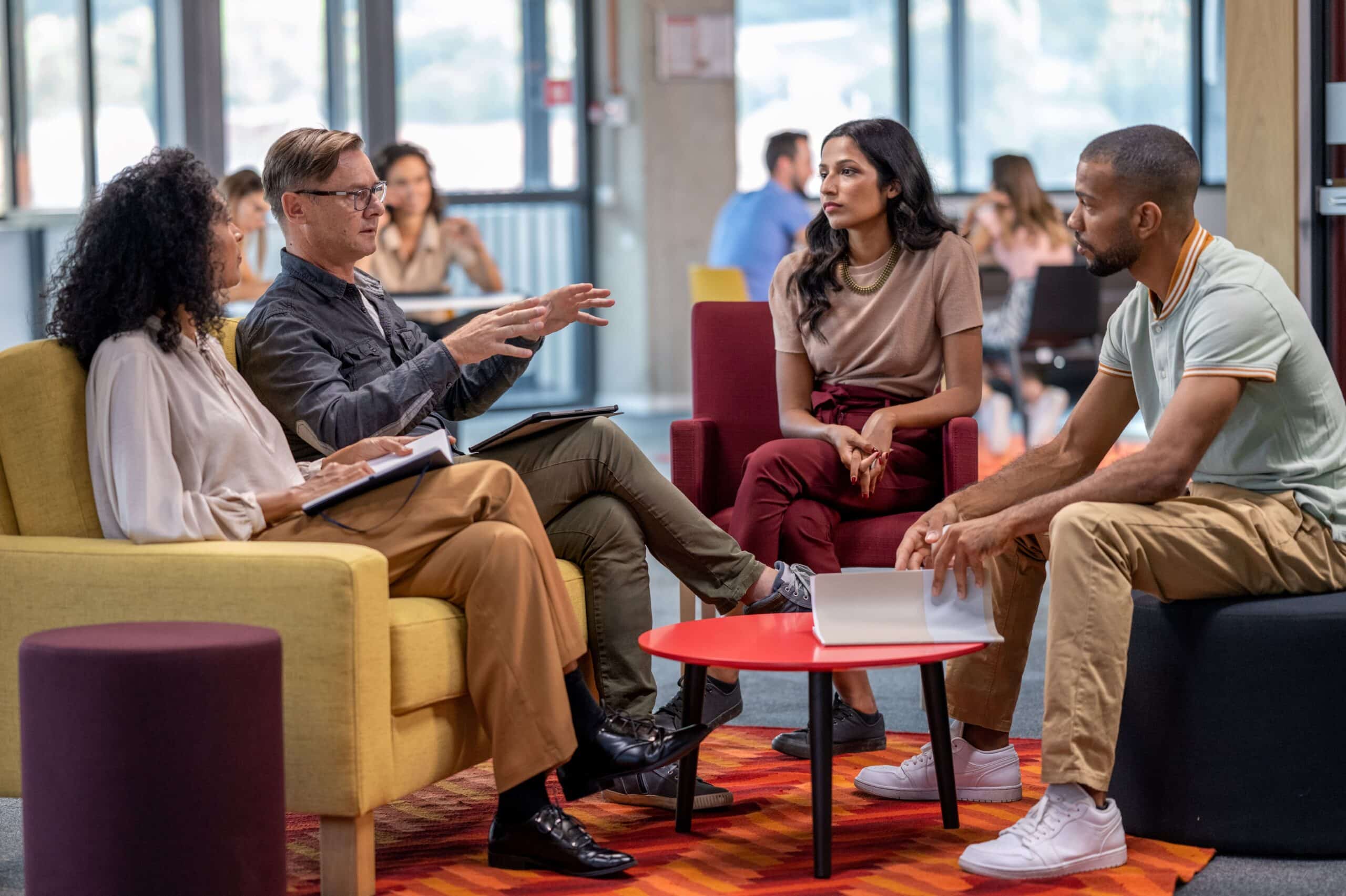 A group of talent acquisition specialists sit together in a discussion