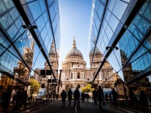St Paul's through a glass building alleyway against blue sky